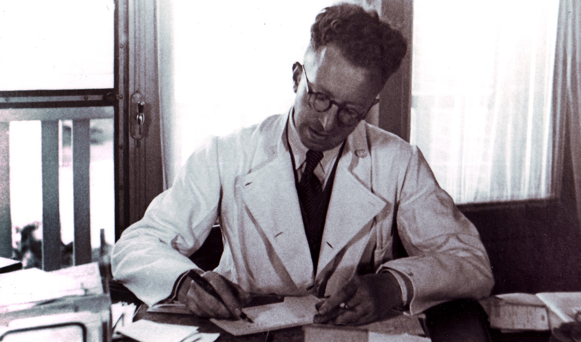 Dokter A.J.J. van Gemert (1909-1967) in de spreekkamer van zijn praktijk aan de Hartveldseweg 49 in 1943.