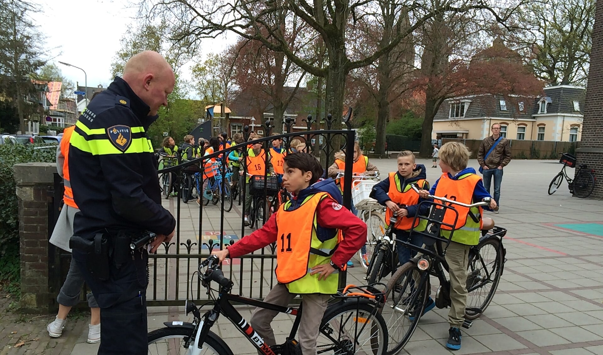 Een agent controleert of de fietsen wel veilig zijn en de leerlingen de weg op mogen.