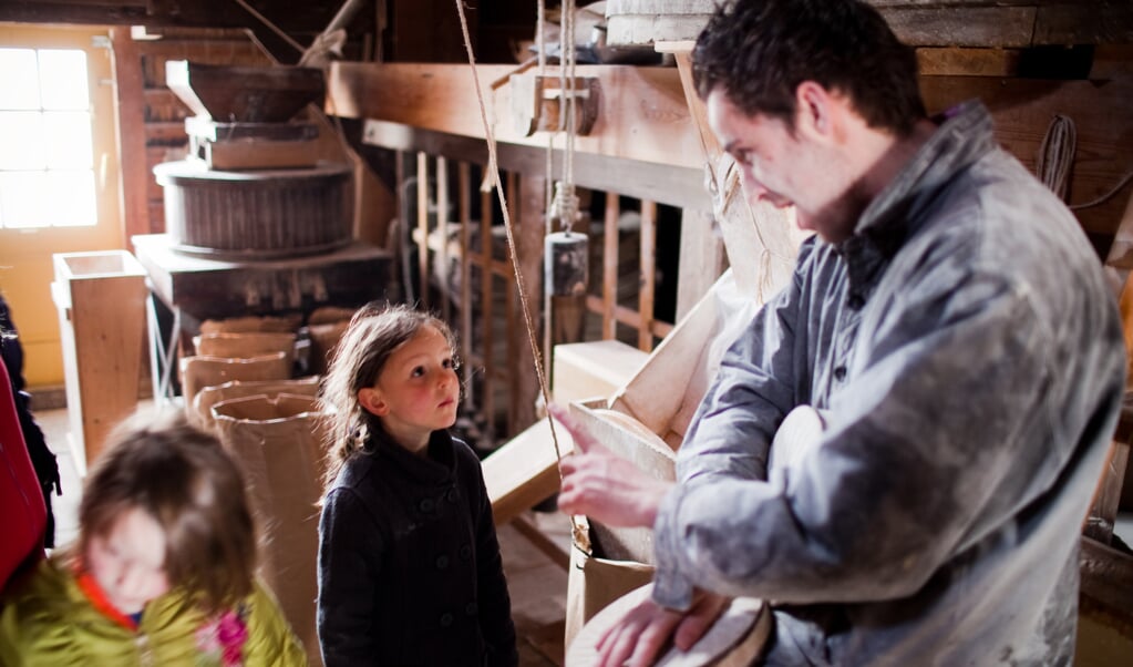 Kinderen krijgen uitleg van de molenaar op Molendag