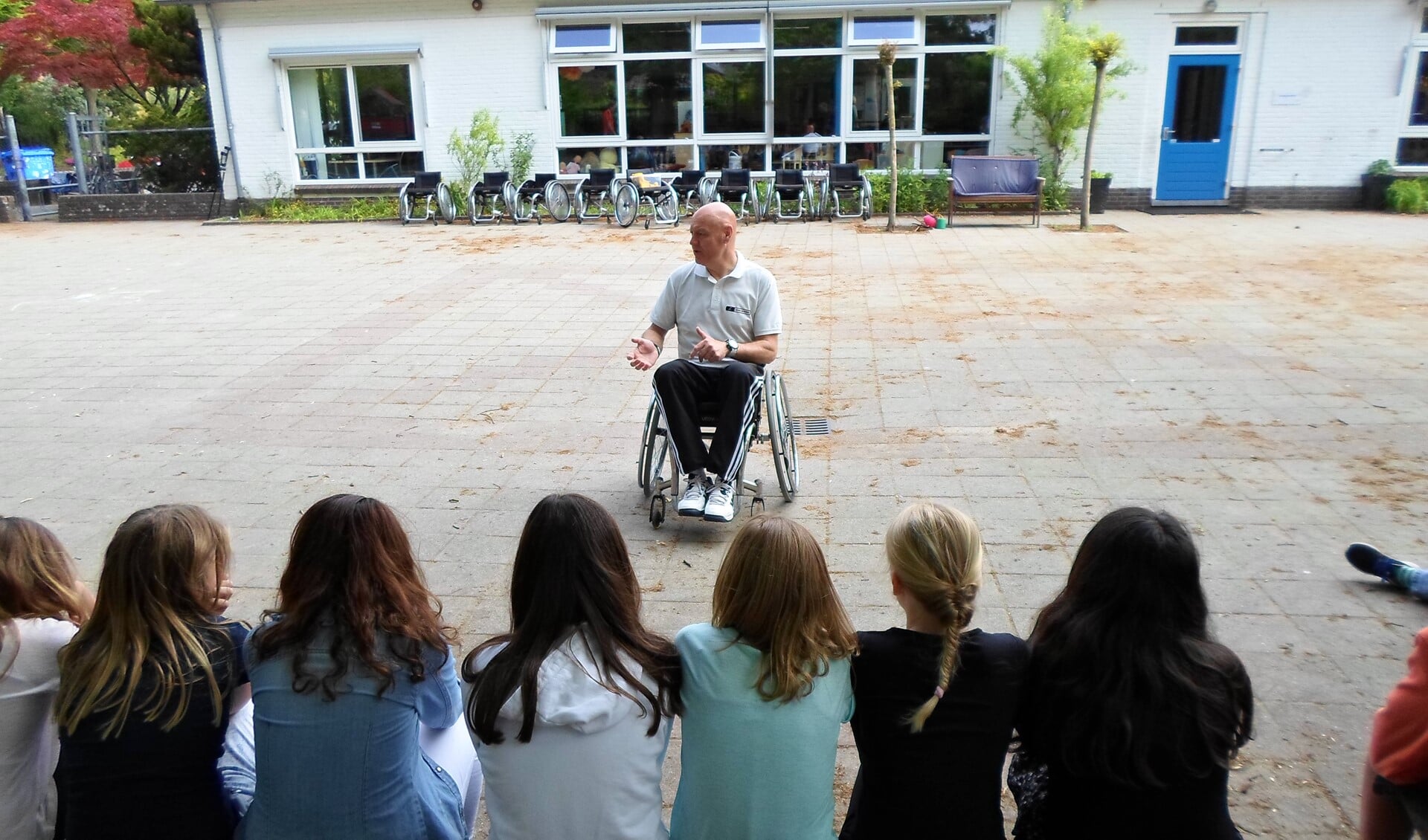 John legt de leerlingen uit waar ze rekening mee moeten houden als ze zelf in de rolstoel zitten.