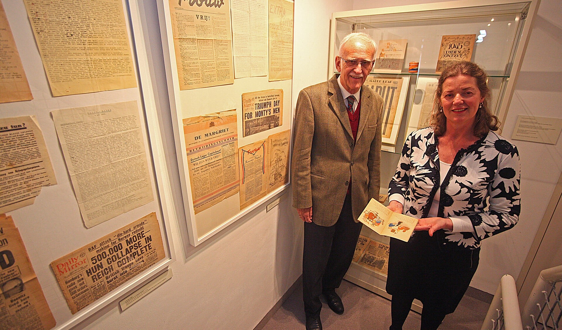Henk Schipper met conservator Margriet van Seumeren bij krantenartikelen over de periode rond de bevrijding.