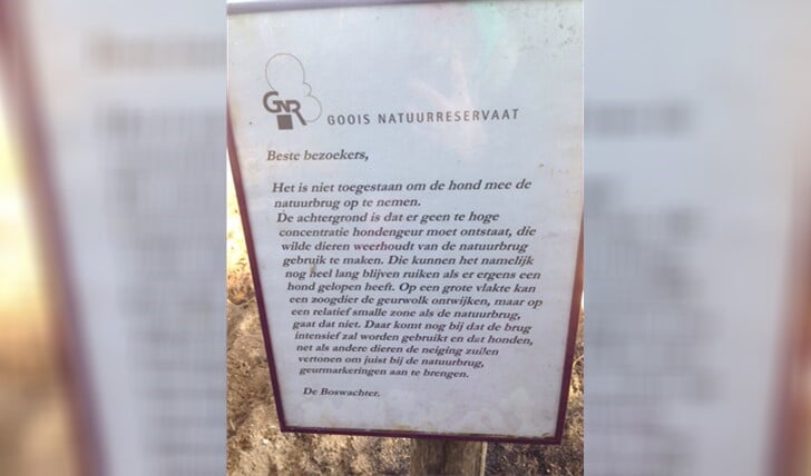 De boswachter geeft uitleg via een bordje op de natuurbrug Laarderhoogt over het hondenverbod.