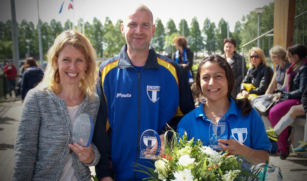 Sandra Vrijenhoek, Alex van der Kolk en Dewi Dekker ontvangen een FC Weespertje.