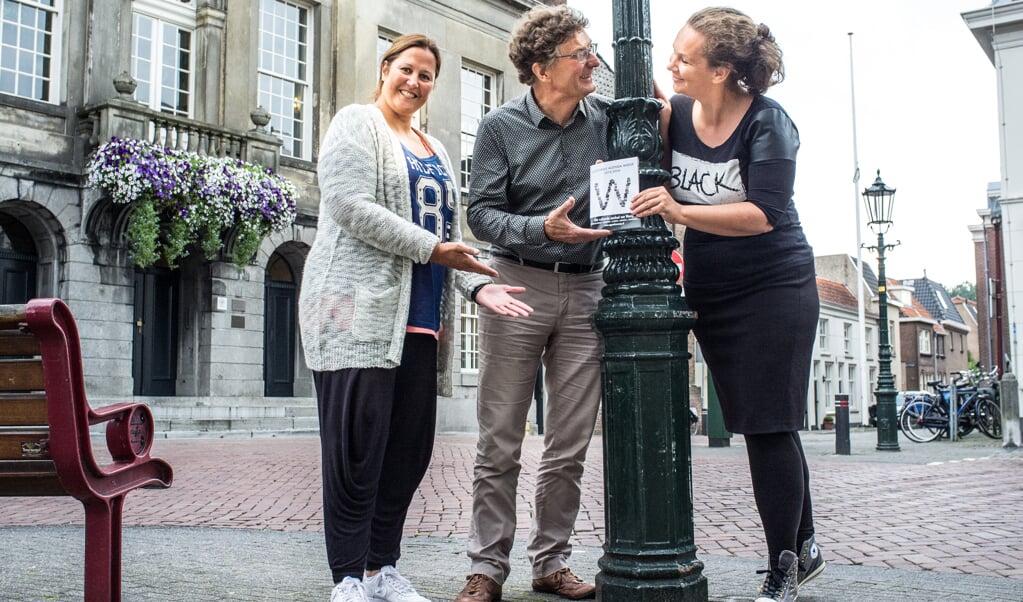 Danielle Meijer en Sara Kroos reiken eerste exemplaar uit aan wethouder Eijking (midden.