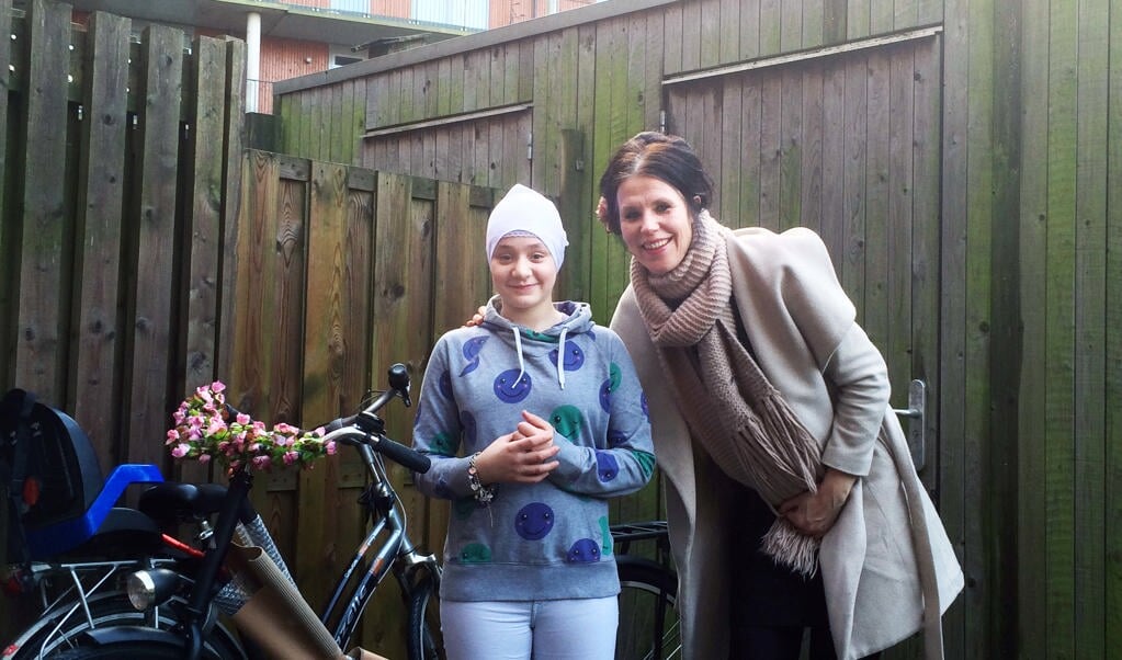 Marjan van der Meer levert fiets af bij Syrisch meisje.