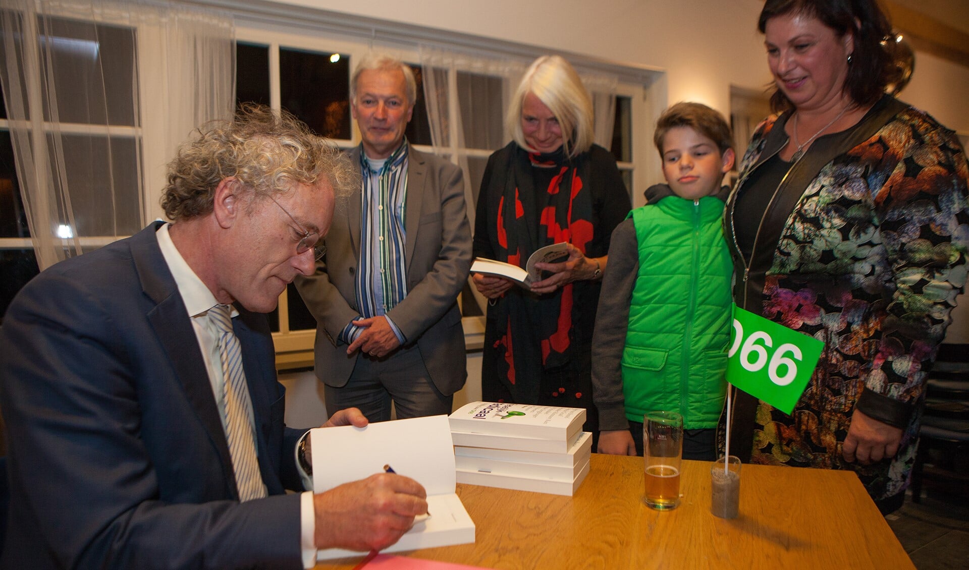Thom de Graaf signeert het jubileumboek tijdens het D66-feestje in Laren.