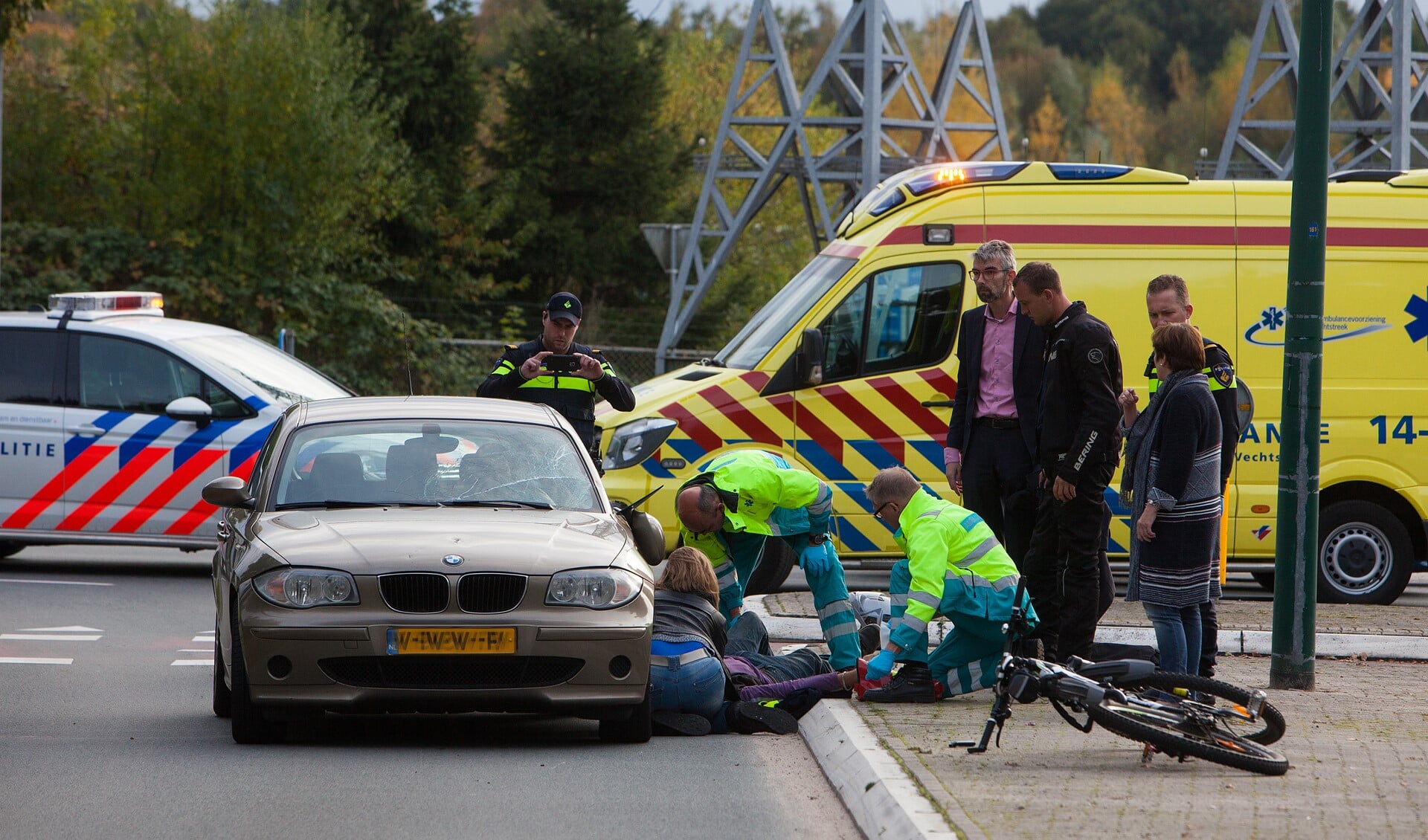 Ambulancepersoneel helpt de fietser die door de automobilist niet op tijd werd gezien.