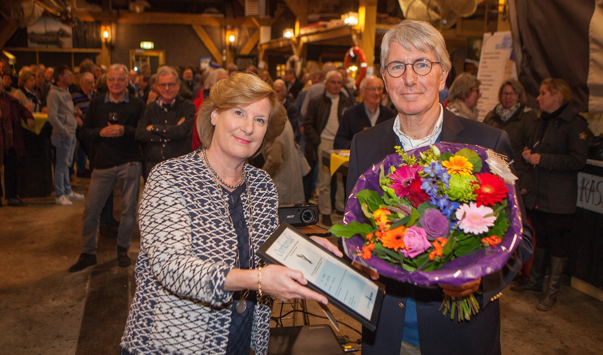 Een bos bloemen en het Huizer Insigne voor Gert Jan Schaap bij zijn vertrek als voorzitter van de Stichting Huizer Botters.