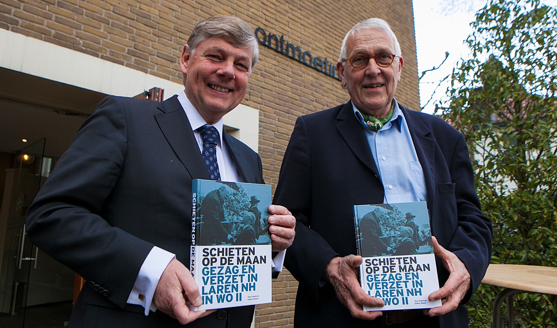 Auteurs Elbert Roest (l) en Teun Koetsier met hun boek Schieten op de maan voor de Ontmoetingskerk.