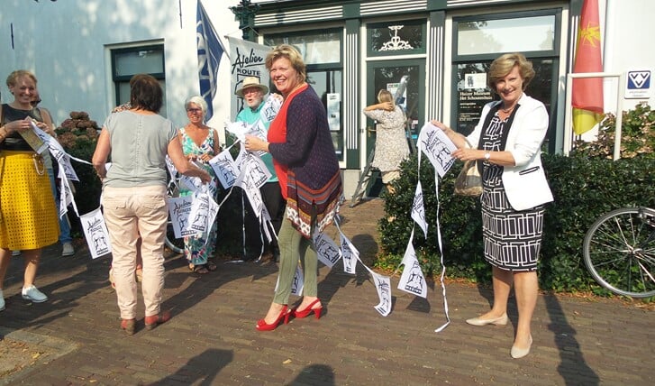 De vlaggetjes worden opgehangen voor de tentoonstelling ter gelegenheid van 20 jaar Atelierroute Huizen.