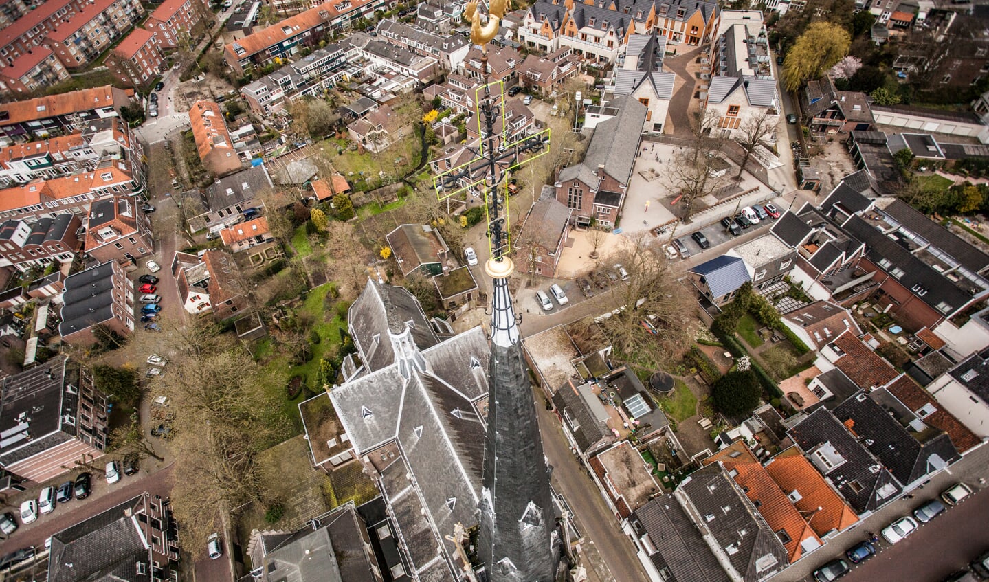 De hoge Laurentiustoren met daarachter het kerkgebouw en de (besloten) tuin.