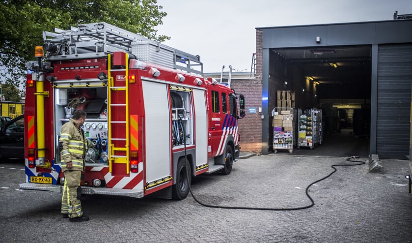 Brandweer bij achterkant winkel.