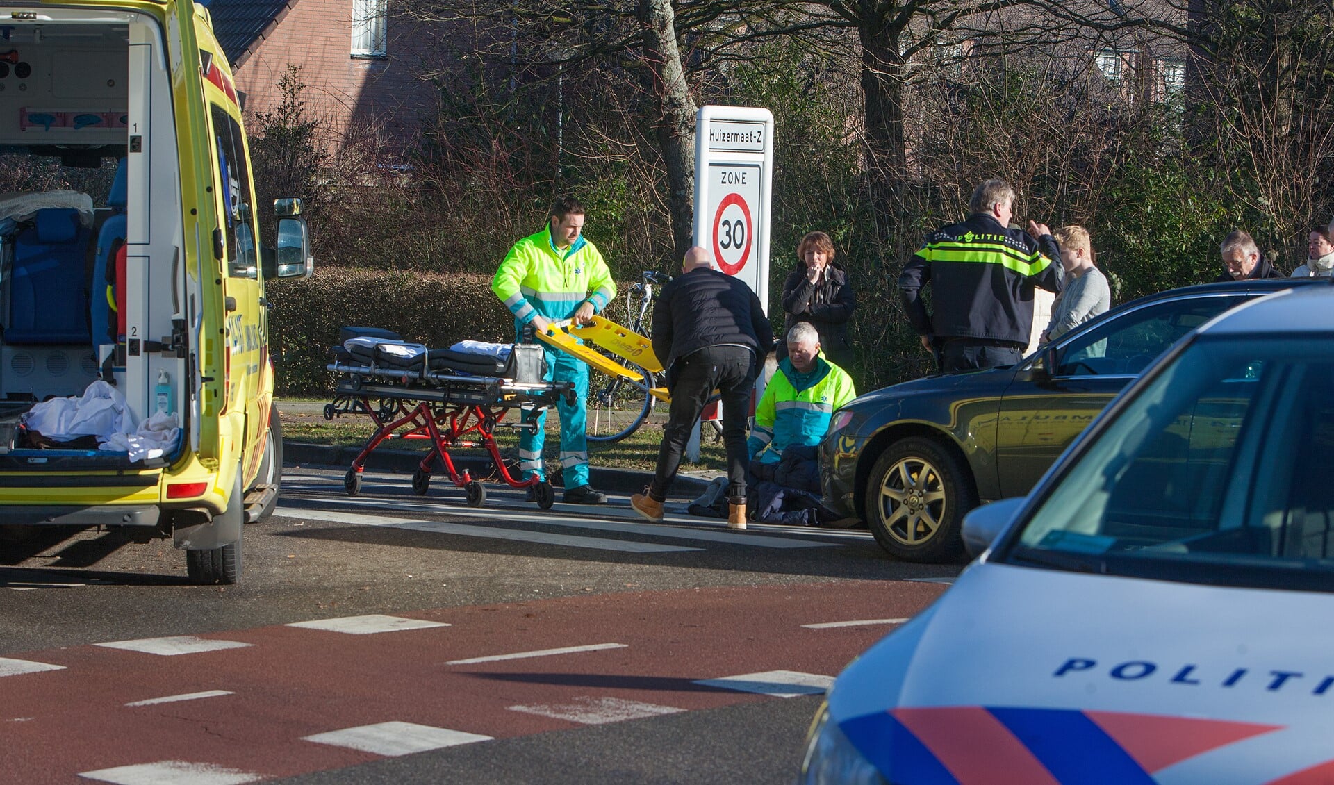 Ambulancepersoneel ontfermt zich over de fietser.