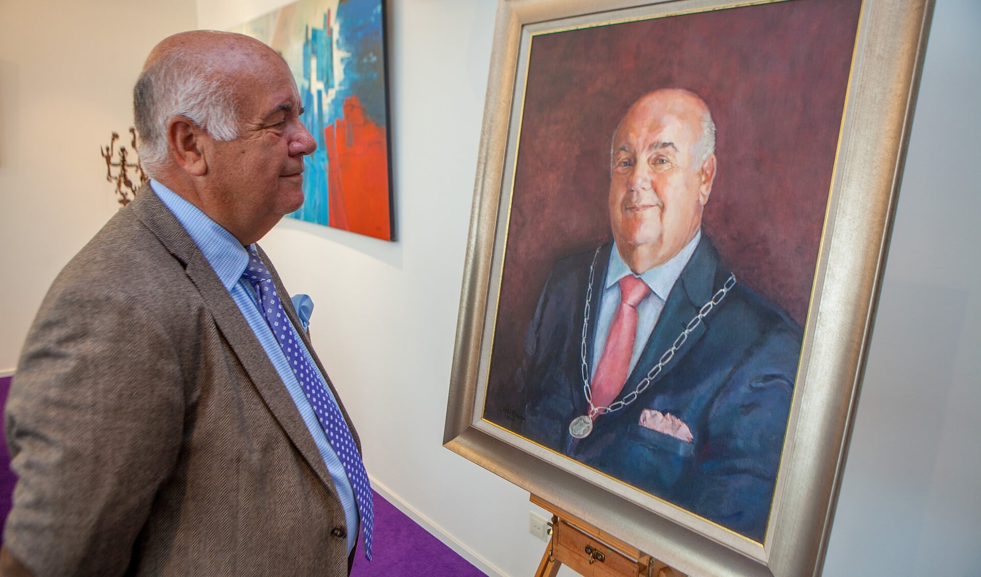 Burgemeester Fons Hartog bekijkt het portret dat Cynthia Halewijn van hem maakte ter gelegenheid van zijn pensionering.