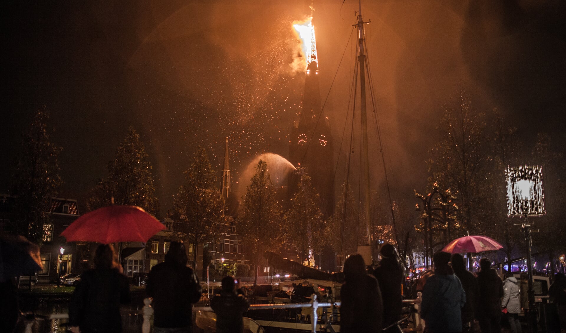 De brandende torenspits voor hij afbreekt en naar beneden stort. 