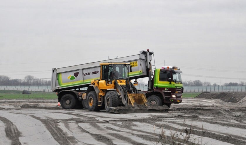 Nieuw zand wordt aangebracht in de polder. Verderop wordt de grond al bouwrijp gemaakt.
