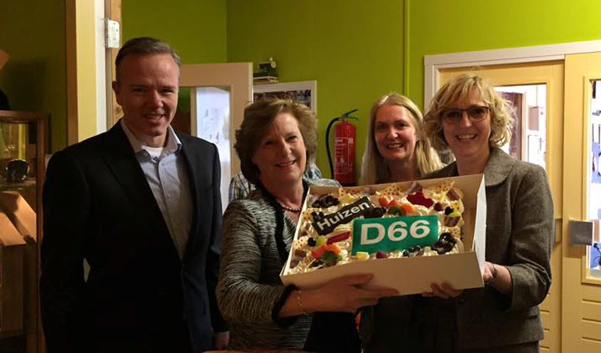 Paul Lekkerkerker, wethouder Marlous Verbeek en Karin van Werven van D66 overhandigen Astrid Veerman van Tijd voor Meedoen de taart.