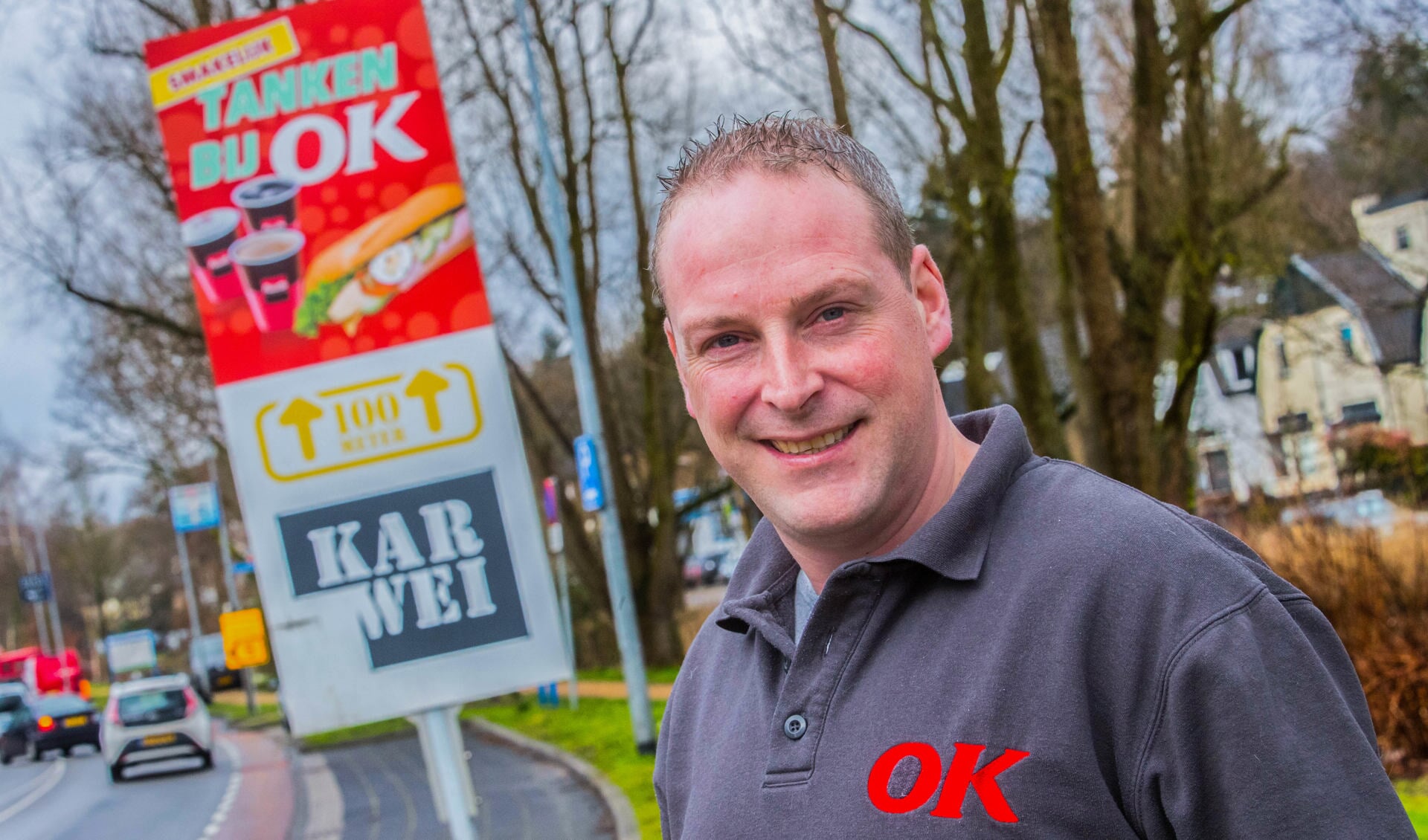 Stationmanager Jeroen van der Linden poseert voor het bord dat OK wil vervangen. Foto: Bastiaan Miché