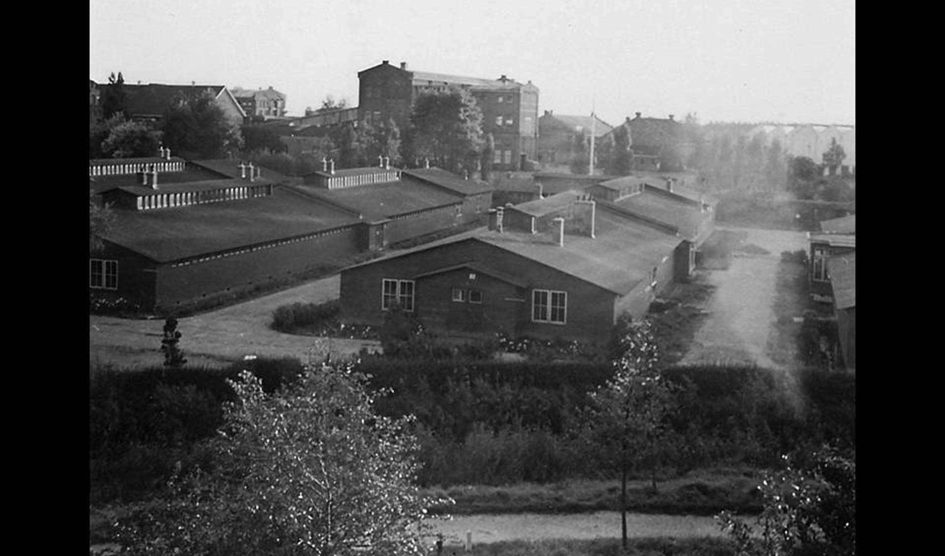 Het barakkenkamp gezien vanaf de Singel, kort voor de afbraak in 1961. Op de achtergrond de fabrieken van Van Houten.
