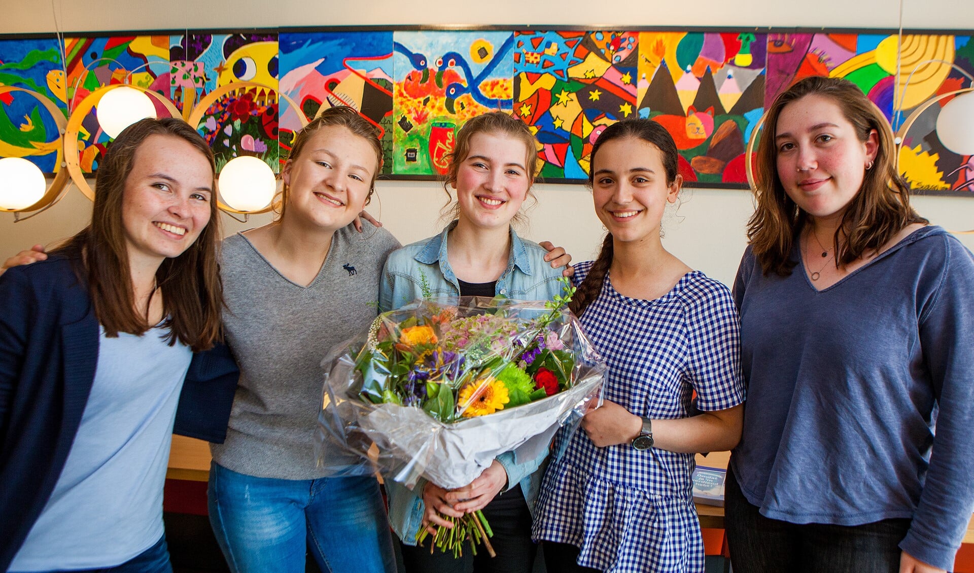 Avigal met enkele klasgenoten en de bos bloemen die ze van de wethouder heeft kregen.