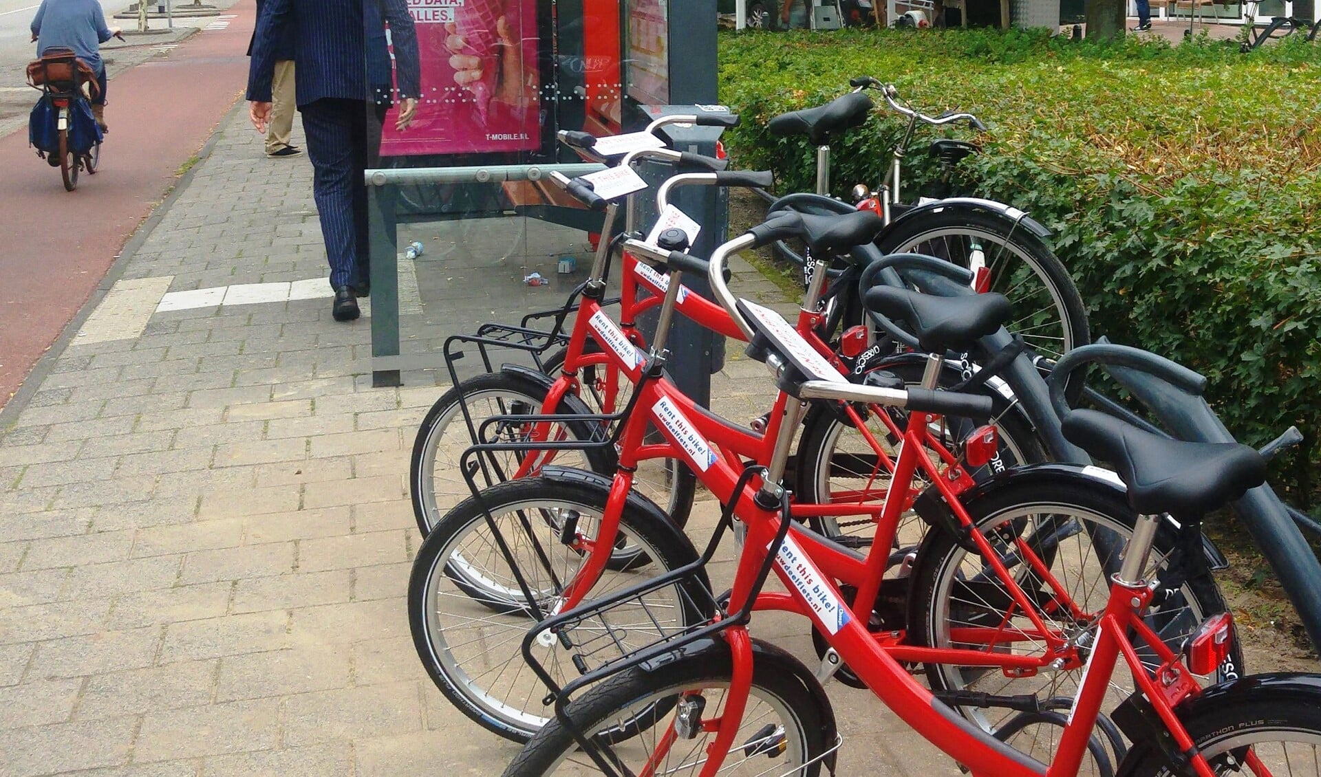 De rode fietsen staan bij het busstation en kunnen gehuurd worden.