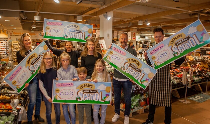 Vertegenwoordigers van de scholen nemen de cheque in ontvangst.