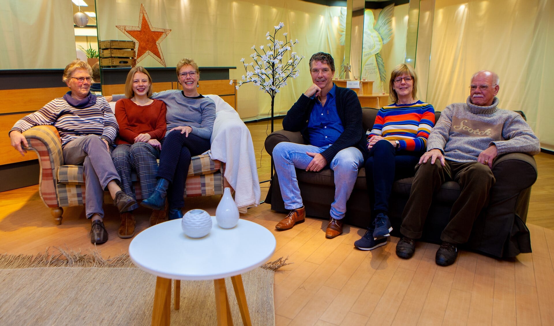 Jan Verkerk, derde van rechts, in de relaxhoek met enkele vrijwilligers die druk zijn om van de winkel een herberg te maken.