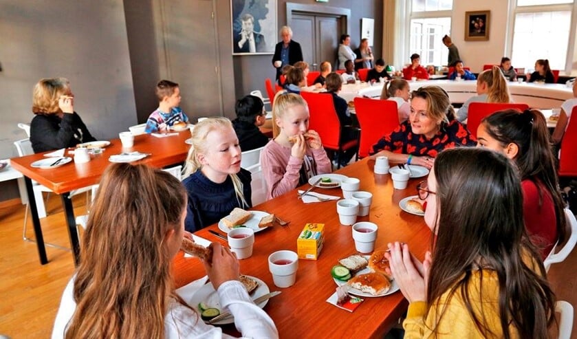 Wethouder Karin van Hunnik samen met de leerlingen aan de ontbijttafel.