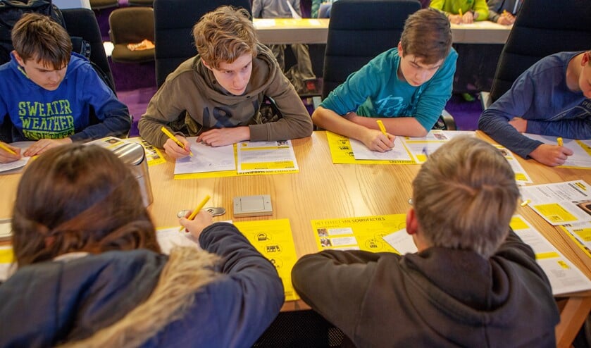 Scholieren schrijven kaarten en brieven in het gemeentehuis.