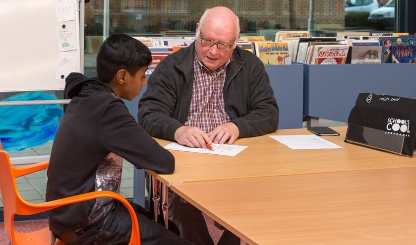 Mentor Ben Grajer ondersteunt Akram.