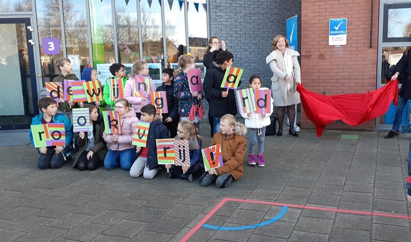 Onder toeziend oog van de leerlingen onthullen de wethouders het bordje rookvrij.
