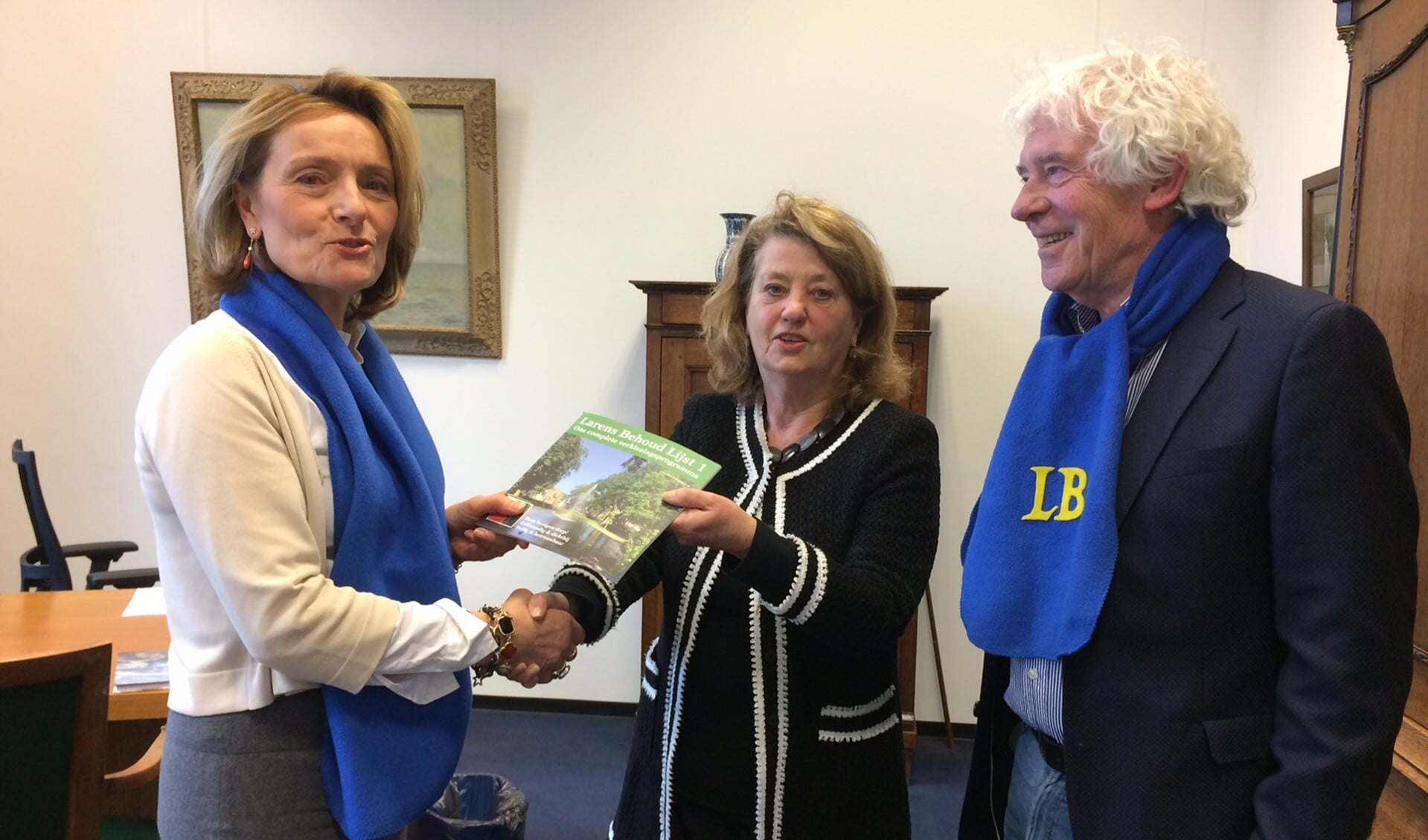 Karin van Hunnik overhandigt - in het bijzijn van Peter Calis - het eerste Larens Behoud-magazine aan burgemeester Rinske Kruisinga.