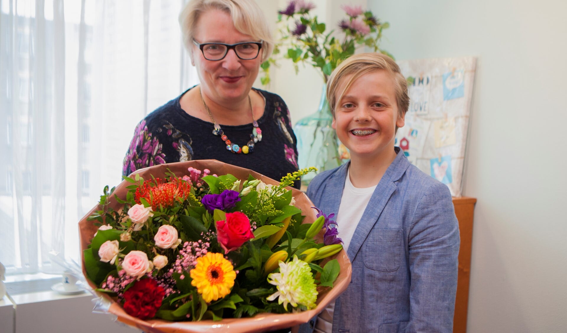 Wethouder Marianne Verhage overhandigd Daan een bos bloemen en een Pluim.