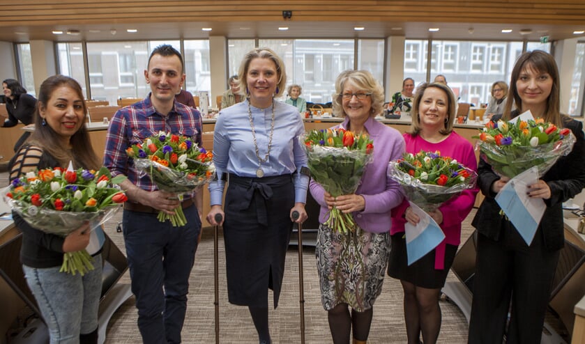 De nieuwe Nederlanders op de foto met de wethouder.