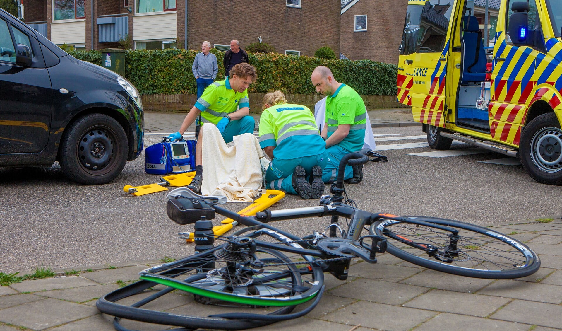 Ambulancepersoneel behandelt de aangereden wielrenner.
