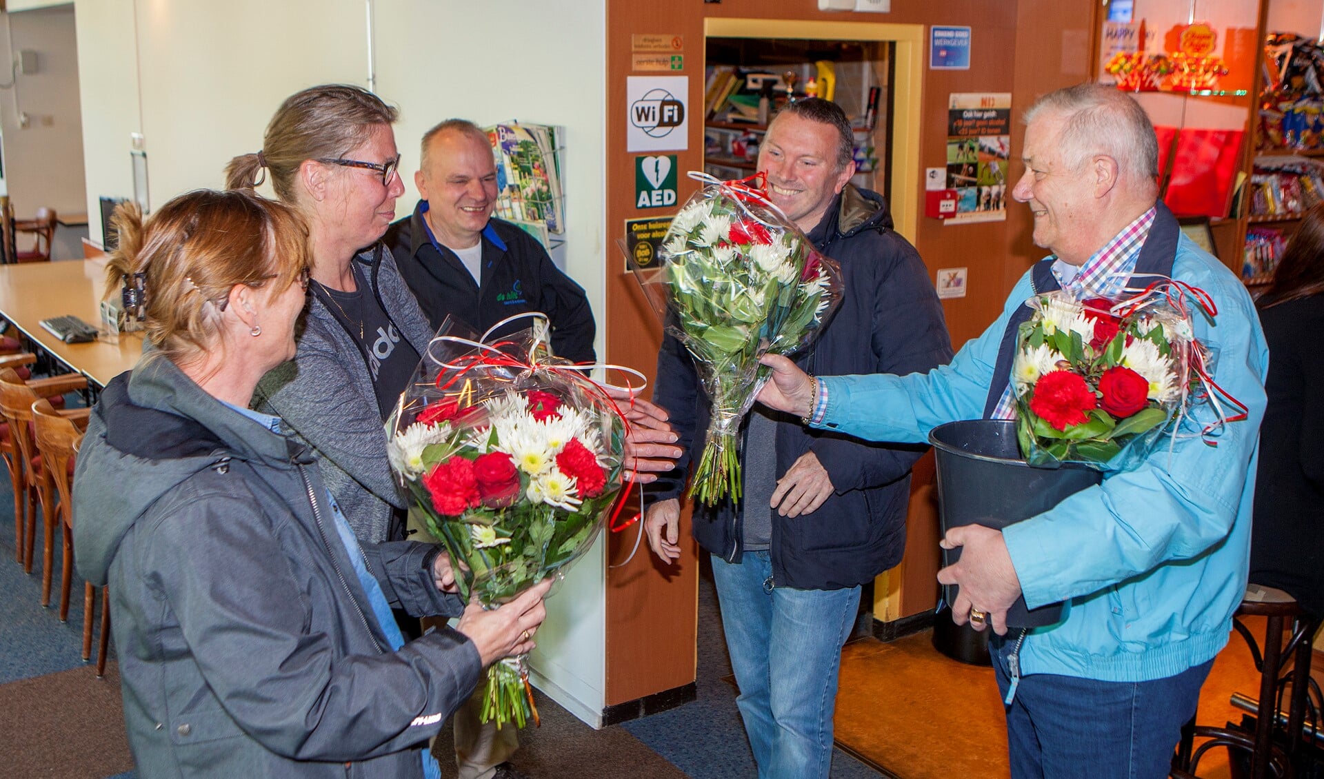 Van links naar rechts: redders Kitty, Sasha en Wilfried krijgen een bloemetje van Derk Jan en Karel.