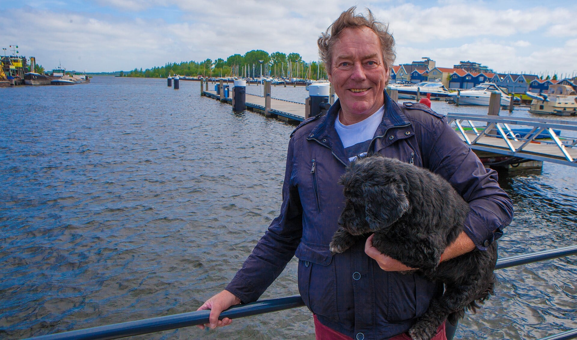 Organisator en openwaterzwemmer Hans Koster met zijn trouwe metgezel Fritz bij de haven waar straks weer gezwommen wordt.