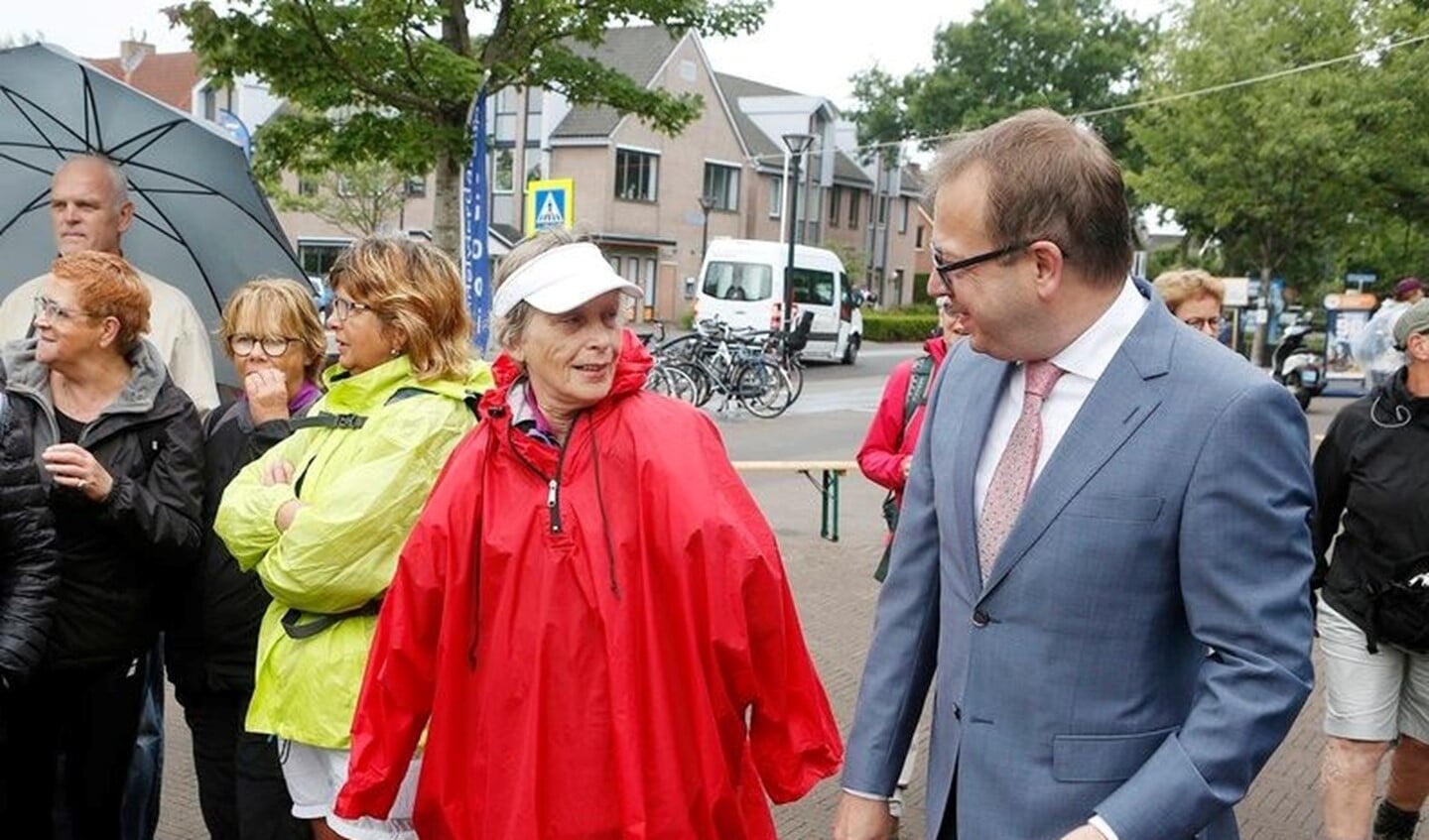 Burgemeester Roland van Benthem in gesprek met een van de wandelaars.