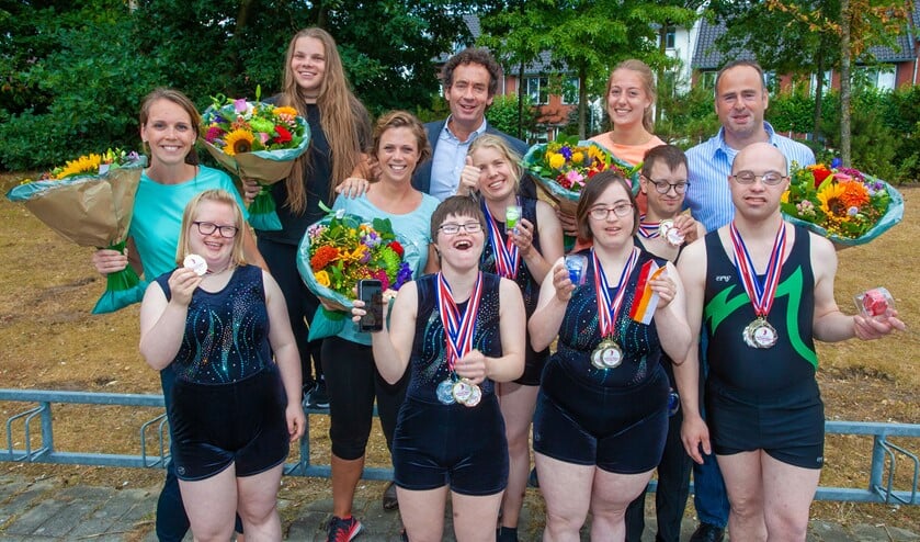 De trotse turners met medailles en de wethouder.