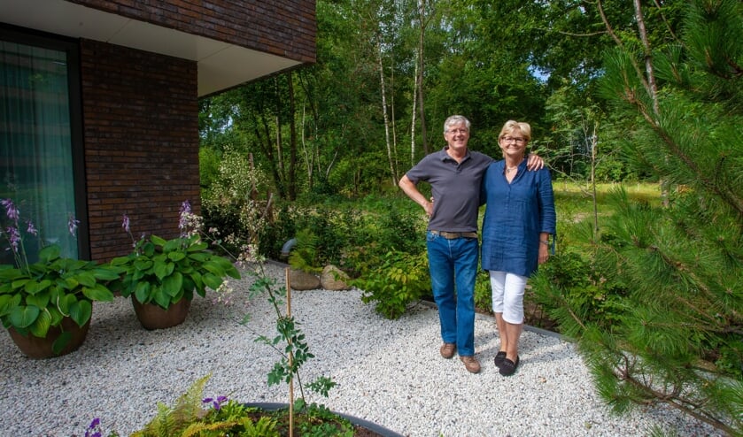 Lex en Irene staan in hun prachtige tuin grenzend aan het bos.