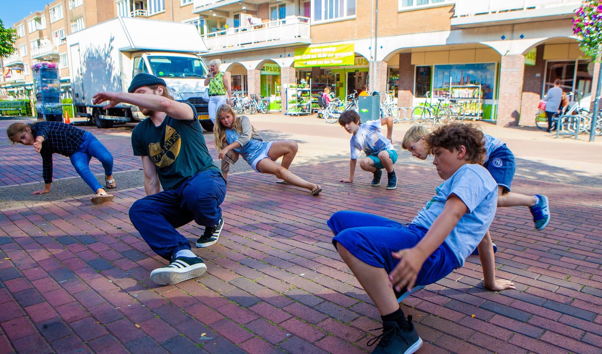Kinderen leren breakdancen tijdens de wekelijkse lessen van Sport in de wijk in Winkelcentrum Oostermeent.