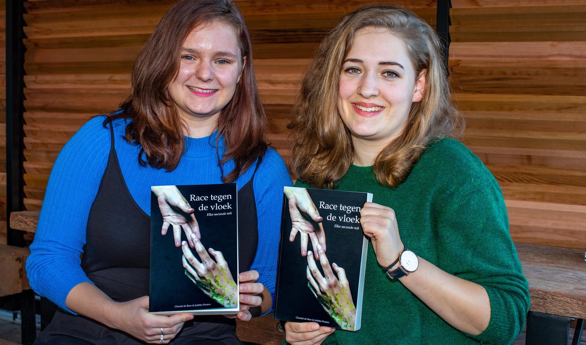 Chantal de Boer (l) en Juliëtte Peeters met hun debuutroman 'Race tegen de Vloek'.