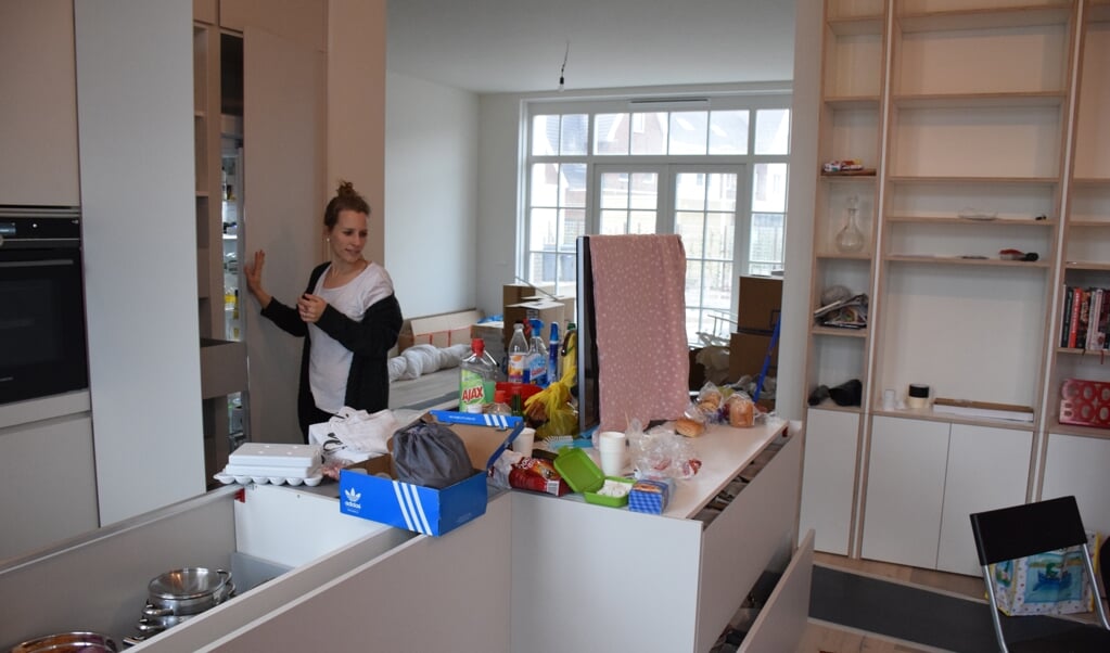 Jitske ruimt de kasten in de keuken van haar nieuwe woning in Weespersluis in.