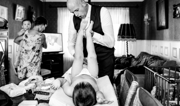 Bruidegom Jan verschoont een van zijn kinderen tijdens 'the getting ready'.