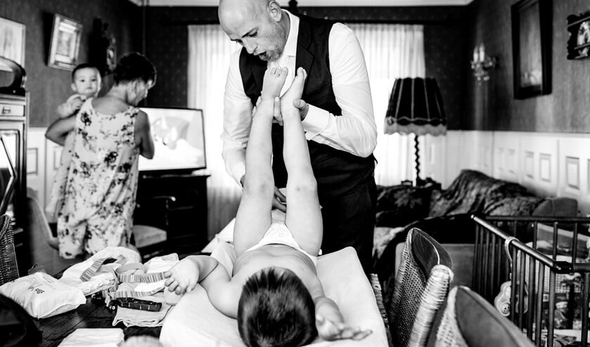 Bruidegom Jan verschoont een van zijn kinderen tijdens 'the getting ready'.