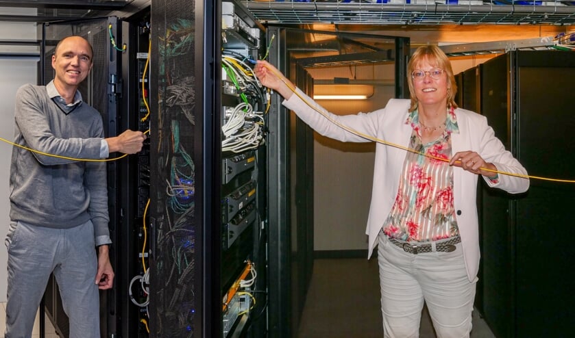 Wethouders Walters (rechts) en Hendriks die symbolisch vanuit hun eigen serverruimtes de draad met elkaar verbinden.