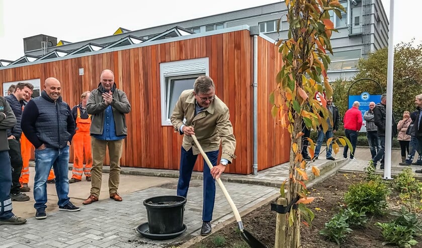 Wethouder Bert Rebel plant een Japanse kers als officiële opening van het gebouw.