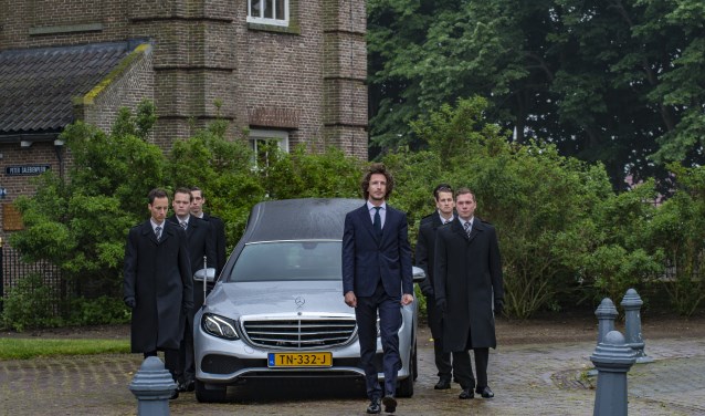 Iede Hoorn (voor de auto) leidt een uitvaart.