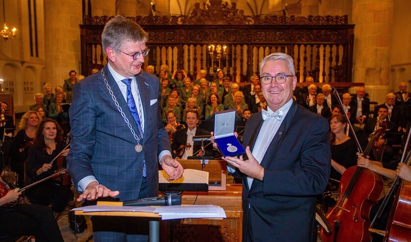 Loco-burgemeester Bert Rebel (l) overhandigde de penning aan zijn broer en de voorzitter van het koor, Eduard Rebel.
