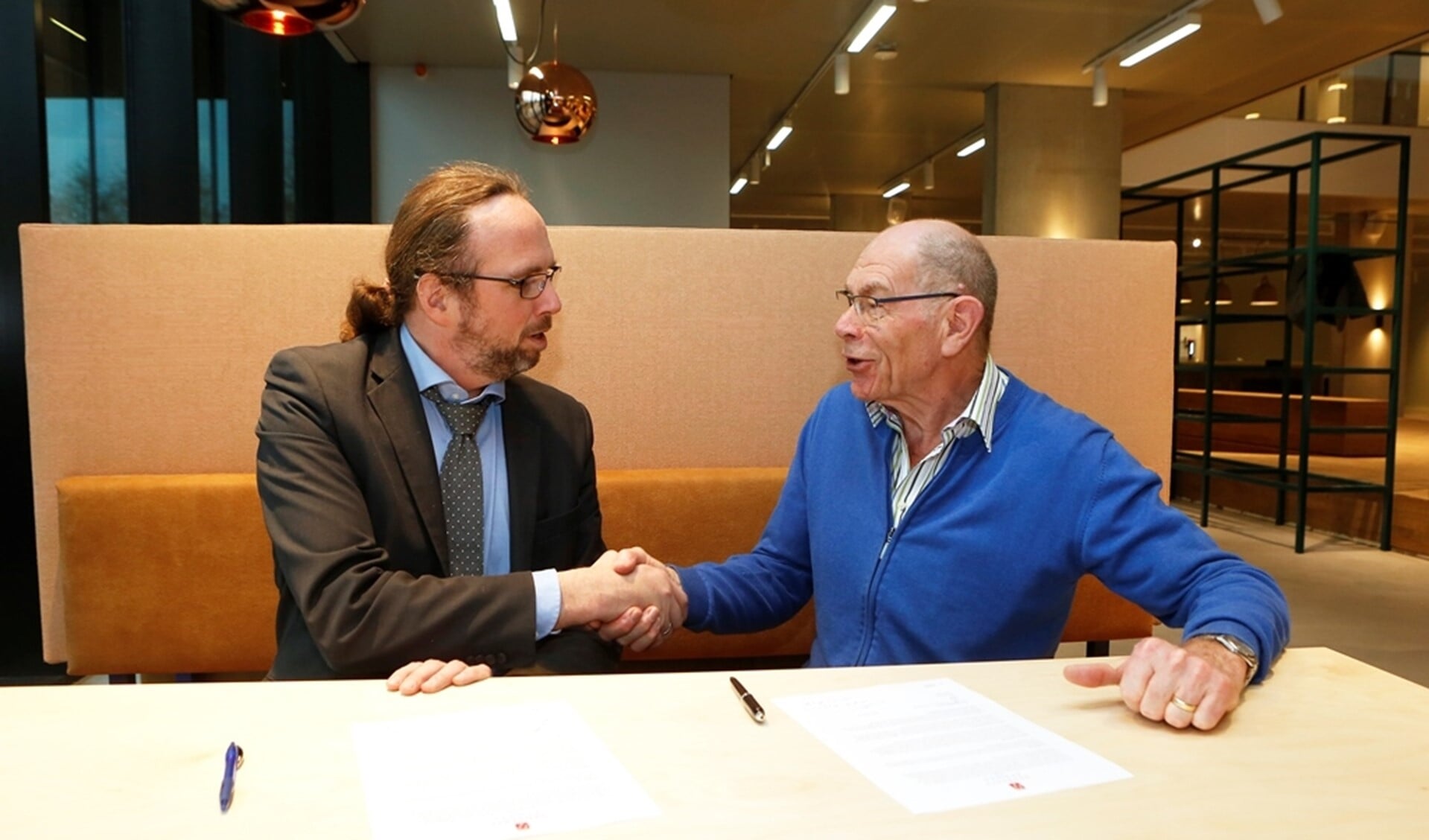 Wethouder Lankreijer (l) schudt de hand met Wim Jongmans (voorzitter Stichting Huis van Eemnes).